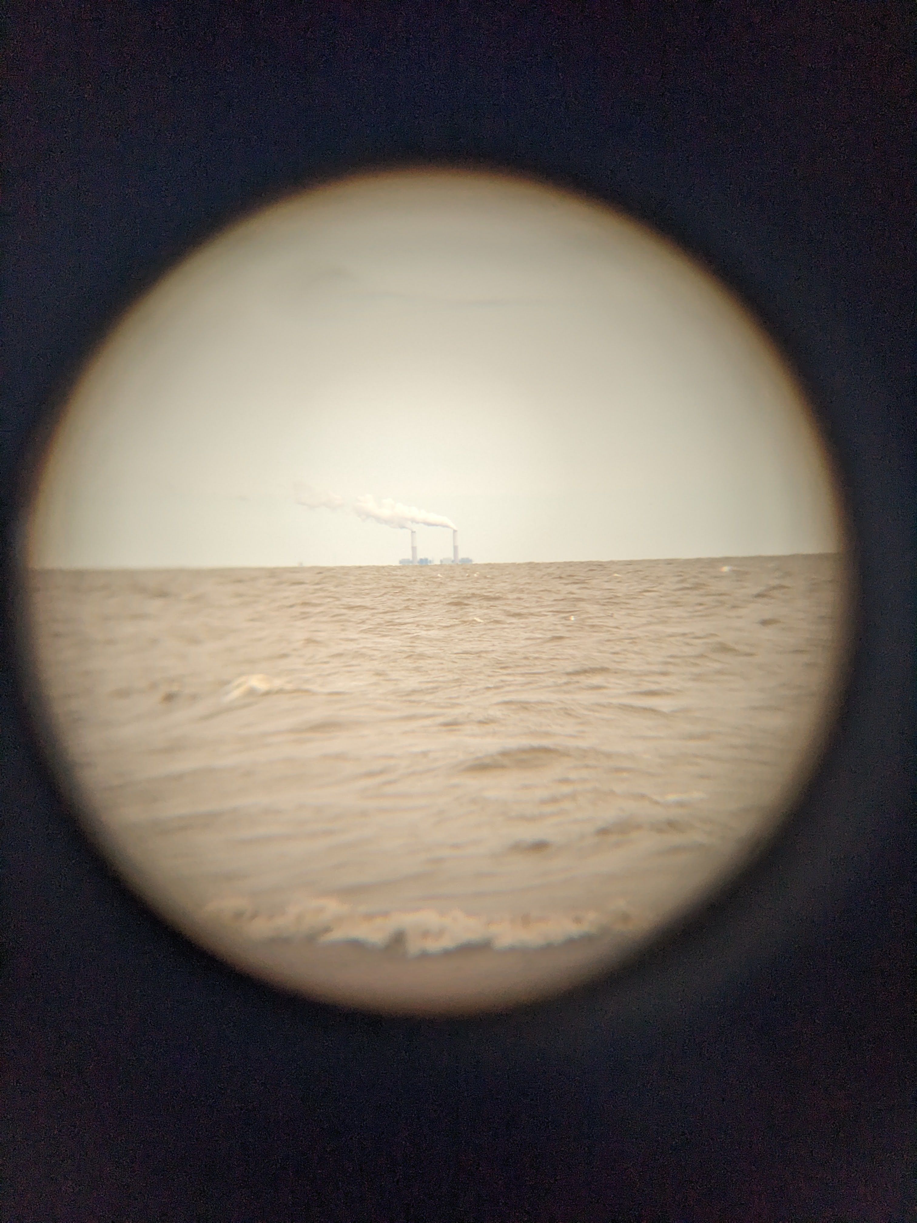 smokestacks across a choppy lake